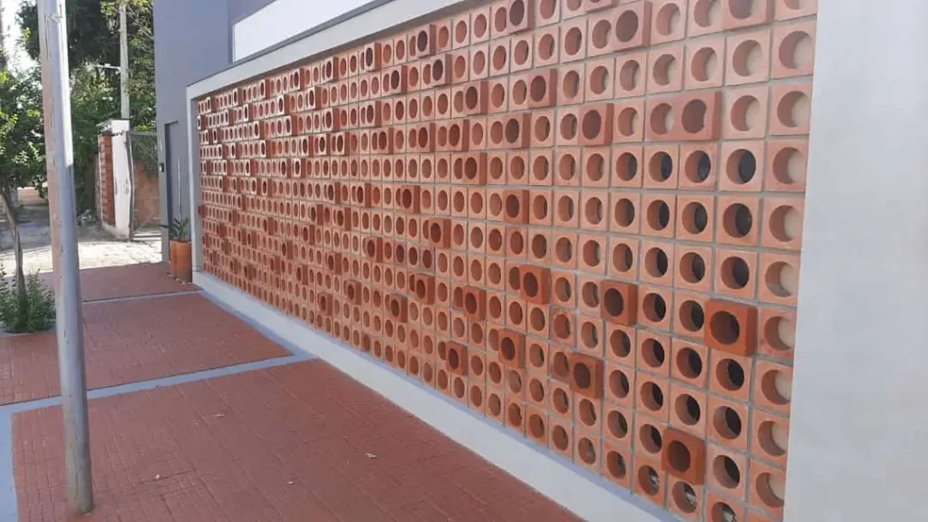 Cobogo Elementos Vazado de cerâmica natural, modelo Mercúrio do Reformar Minha Casa. Instalado como muro da fachada. 